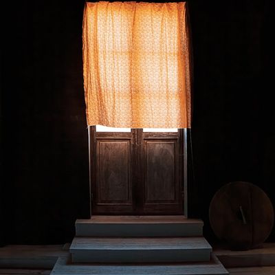 Sunlight filtering through white curtains onto a wooden floor